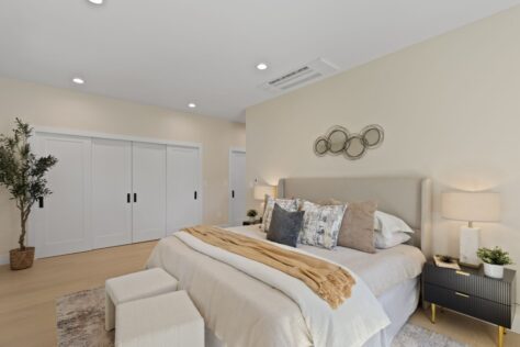 Interior Chapin Master bedroom with kingsize bed, end stools and ringed wall mirror accent 0160 143kb