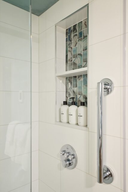 Basement shower with recessed tile shelf above faucet.