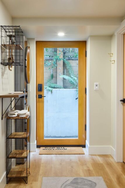 Basement entry door from inside. Partially below ground retaining wall visible through door glass.
