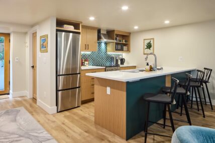 Basement kitchen with bar stools at counter.
