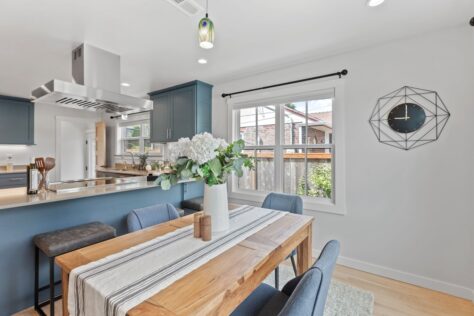 Kitchen 24th Ave Dining Room with wood table and modern blue-grey kitchen in background 0015 212kb