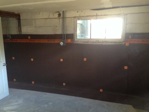 Water barrier applied to interior of basement wall after house lift.