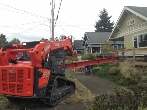 Backhoe lifting support beams to lift house