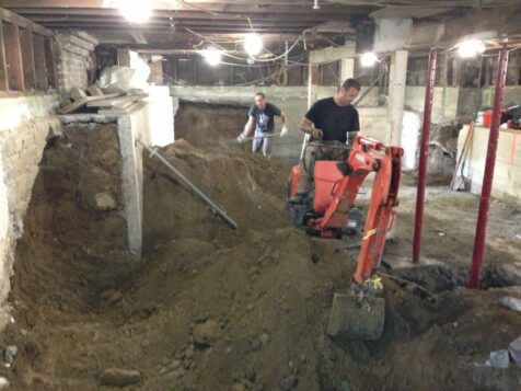 Crew excavating basement with backhoe