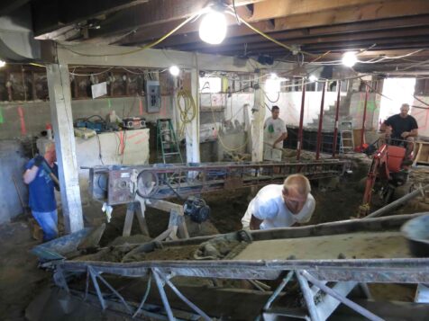 Work crew excavating basement using conveyor belts