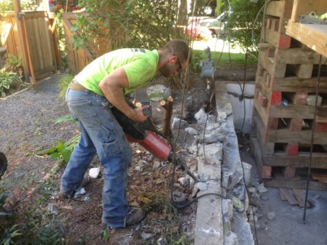 Man jack hammering old foundation