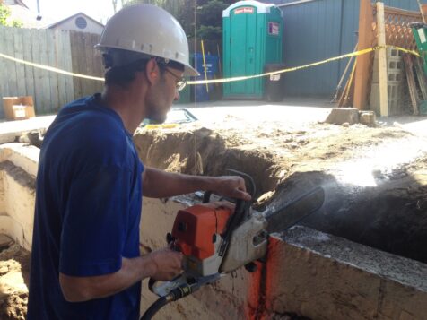 Man cutting into old foundation