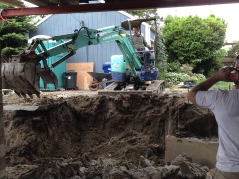 View from under lifted house. Backhoe.