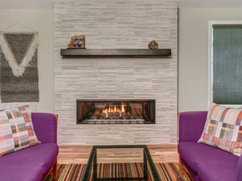 Modern low fireplace with purple chairs on either side